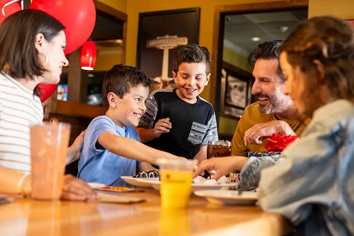 3 men watching a football game at happy hour at an Applebee's sports bar near them.